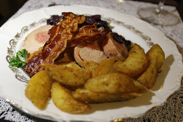 filet mignon stuffed with pork and baked potatoes with fried bacon