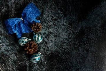 
Dark Christmas background for congratulations with blue bell and ice cubes.