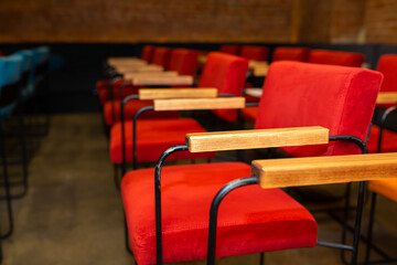 Red and blue chairs in the dark hall of a small cinema