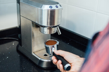Detail of man's hands preparing an espresso
