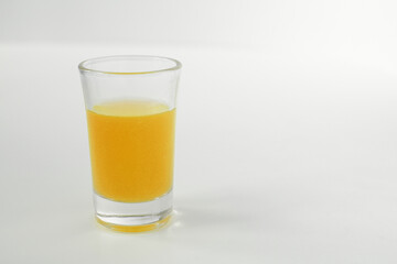 Shot of yellow in a glass. Glass of yellow alcohol. 