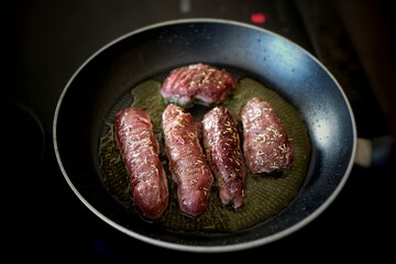 fresh cooking at home, healthy venison meat from the chamois, rupicapra rupicapra, roasted in a pan with herbs 