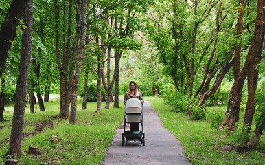beautiful young mom walks with a stroller