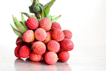 A bunch of fresh Thai Lychees on gray table with white and bright background