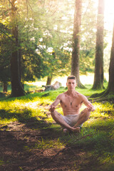 Young man doing yoga in the forest.