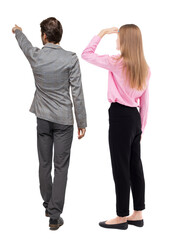 Back view of business man and business woman in suit pointing.
