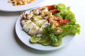 Riceberry with omelette With steamed lemon seafood served in a white round dish Put on the white table Ready to eat