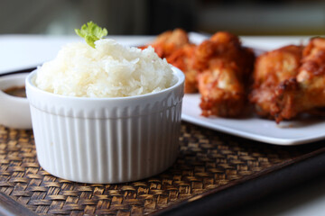 Sticky rice with fried pork served with Jaew Thai dipping sauce, placed on a wooden tray Ready to eat