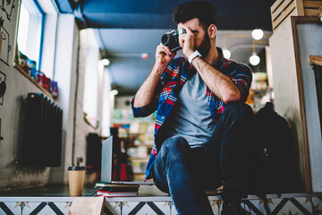 Portrait of handsome hipster photographer dressed in casual shirt smiling at camera.