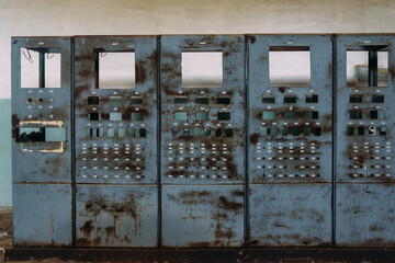 Broken electrical switchgear cabinets with control panels in abandoned factory