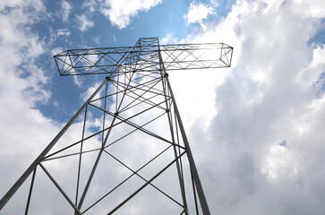 cross over the top of a mountain and the sky with white clouds