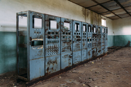 Broken electrical switchgear cabinets with control panels in abandoned factory