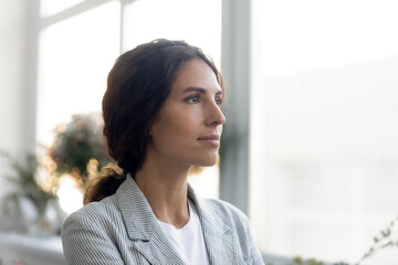 Close up of thoughtful beautiful young Caucasian woman look in distance thinking or pondering,...