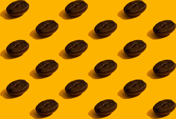 Lots of coffee beans stacked in rows. Seamless pattern in a minimalistic style on an orange background