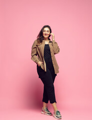 Fashionable, stylish. Young woman in casual wear on pink background. Bodypositive character, feminism, loving herself, beauty concept. Plus size businesswoman, beautiful girl. Inclusion, diversity.