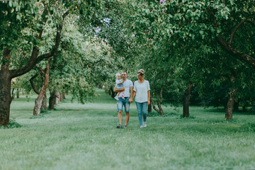 Happy young family. Father, mother and child walking in park on summer. 