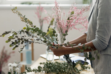 Close up of female florist arrange bouquet make beautiful floral compositions at home, woman...