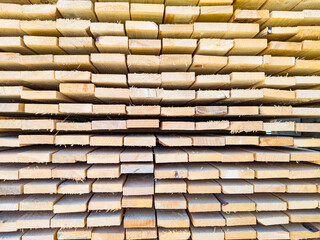 A large pile of boards sawn from trees on a sawmill for the procurement of building materials for...