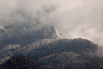 Winter mountain, snow capped and cloud covered