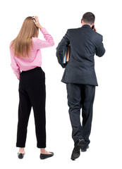 Back view of business woman and business man in suit with mobile phone.