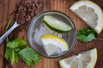 Lemon drink on the wooden table. Top view. cold drink with lemon and lime. sugar and ice. cocktail background