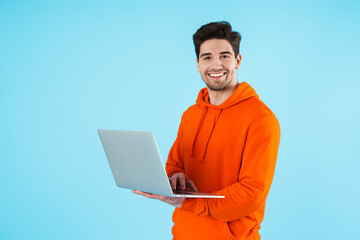 Bristle man isolated over blue wall background using laptop