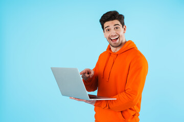 Surprised young bristle man using laptop computer.