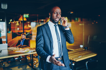 Black businessman speaking on cellphone in office