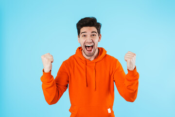 Emotional optimistic young bristle man make winner gesture.