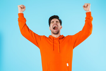 Emotional optimistic young bristle man make winner gesture.