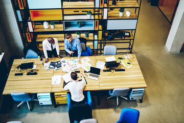 Top view of diversity crew of experienced economists brainstorming during working process in...