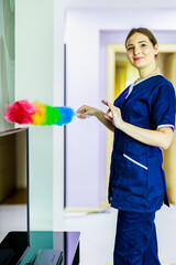 Cleaning service. Cleaning woman. Woman hold colorful dusting brush. Grill cleaner with uniform