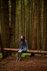 Brunette girl walking on the woods, traveler in romanian carpathian mountains, wears in denim...