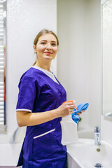 Cleaning. Cleaning in the bathroom. A woman wipes the sink and washbasin faucet.