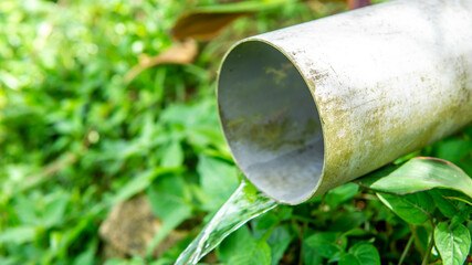 Close up view drain water flowing from the PVC pipe hole. Sanitary sewer concept. Transporting...
