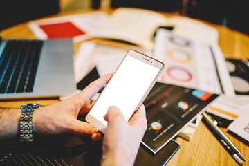 Smartphone in hands on businessman at table