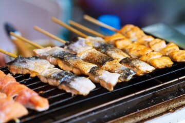 Close up of BBQ Grilled Salmon fish on wood stick thai street food market