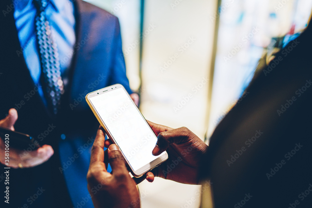 Poster cropped view of businessman's hands holding smartphone device with blank screen for internet content