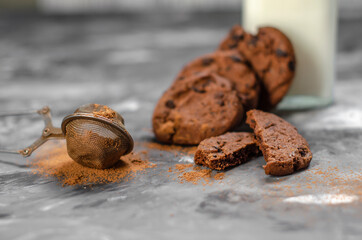cookies with pieces of chocolate tied with a thread lie on a table sprinkled with cocoa powder