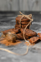 cookies with pieces of chocolate tied with a thread lie on a table sprinkled with cocoa powder