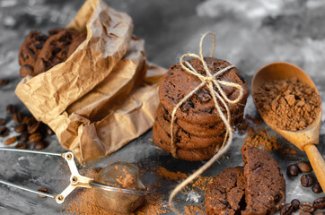 cookies with pieces of chocolate tied with a thread lie on a table sprinkled with cocoa powder