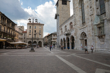 Fototapeta na wymiar Walking on narrow street in Como city with historic buildings and shops