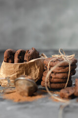 cookies with pieces of chocolate tied with a thread lie on a table sprinkled with cocoa powder