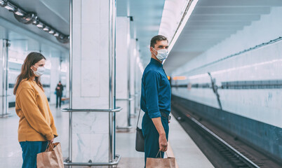 passengers in protective masks waiting for the metro train