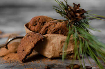 cookies with pieces of chocolate tied with a thread lie on a table sprinkled with cocoa powder