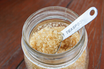 Sugar from sugar cane granulated sugar yellow on stainless spoon