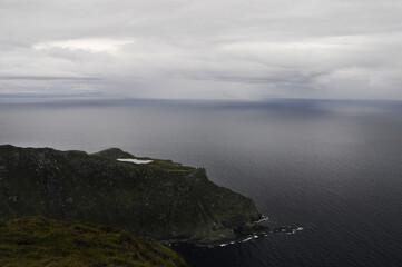Vue sur la mer et un orage, la pluie tombant sous un nuage à l'horizon depuis les falaises au nord de l'Irlande.