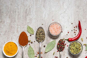 Spices and herbs on light marble table top view.