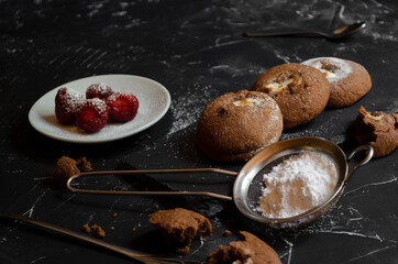chocolate chip cookies on a table with strawberries and icing sugar