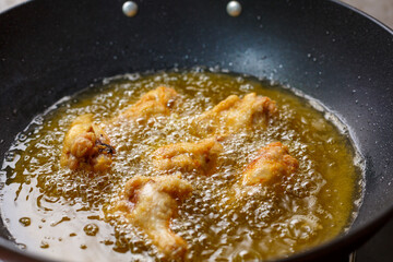 Close up fried chicken wings in boiling oil